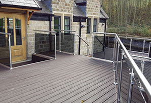 An outside deck with sunken hot tub, walkway & glass hand railing. Designed, supplied & installed by ASH Construction Ltd.