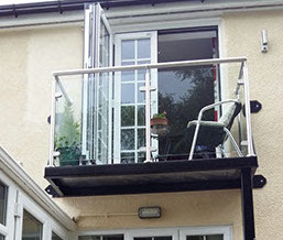 An outside deck with sunken hot tub, walkway & glass hand railing. Designed, supplied & installed by ASH Construction Ltd.